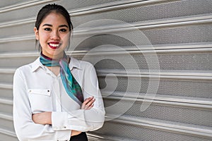 Young scort woman or crew smiling crossed arms green