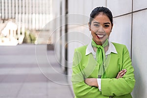 Young scort woman or crew smiling crossed arms green