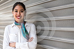 Young scort woman or crew smiling crossed arms green