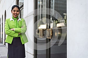 Young scort woman or crew smiling crossed arms green