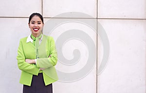 Young scort woman or crew smiling crossed arms green