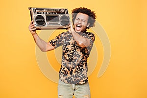 Young screaming african man standing with tape recorder