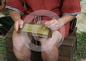 Young SCRIBE writes on a wax Tablet