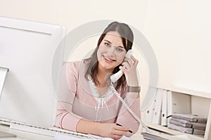 Young secretary on phone at modern office photo