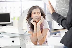 Young secretary sitting shocked in office