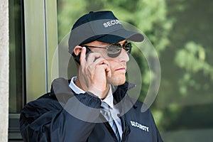 Young Security Guard Talking On Walkie-talkie