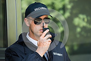 Young Security Guard Talking On Walkie-talkie