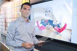 Young seller holding digital tablet in store photo