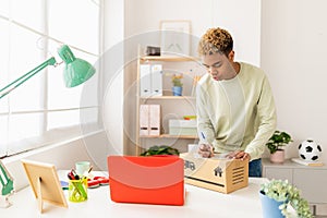 Young seller man preparing second hand package before send to buyer