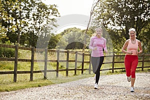 Young And Senior Women Enjoying Run Through Countryside Together