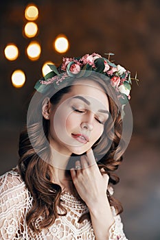 Young sensual beautiful woman with wreath of flowers in her hair dreaming