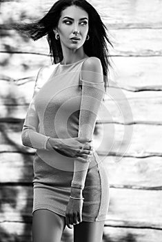 Young sensual & beauty brunette woman pose against wooden background. Black-white photo