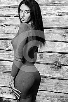Young sensual & beauty brunette woman pose against wooden background. Black-white photo
