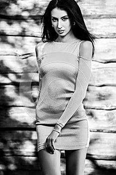 Young sensual & beauty brunette woman pose against wooden background. Black-white photo