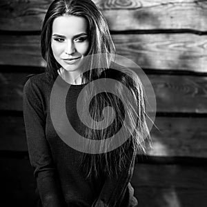 Young sensual & beauty brunette woman pose on wooden background. Black-white photo