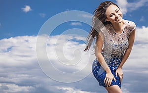 Young sensual & beauty woman in a fashionable dress pose outdoor on sky background.