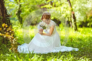 Young sensual bride sitting in a summer