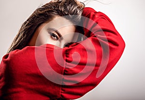 Young sensual model woman in red pose in studio.