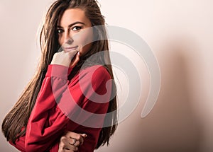 Young sensual model woman in red pose in studio.