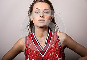 Young sensual model woman in red pose in studio.