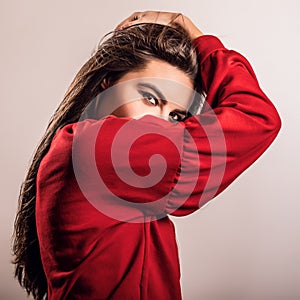 Young sensual model woman in red pose in studio.