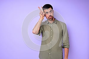 Young serious bearded deaf mute man showing toilet WC gesture