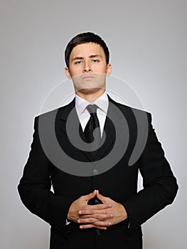 Young serious business man in black suit and tie