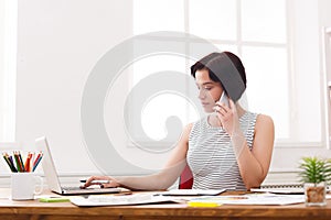 Young serious businesswoman talking on phone