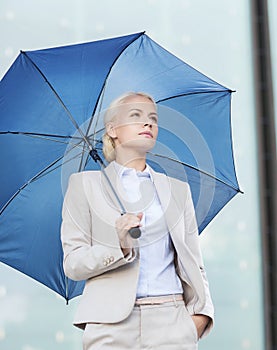 Young serious businesswoman with umbrella outdoors