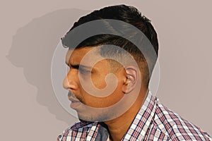 Young serious looking Indian man close up face portrait on isolated background.