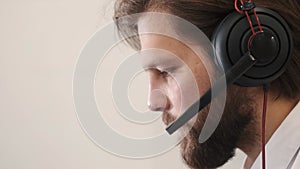 Young serious male call center operator doing his job with a headset
