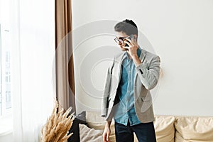 A young serious man is going to work at home and discusses problems on the phone.