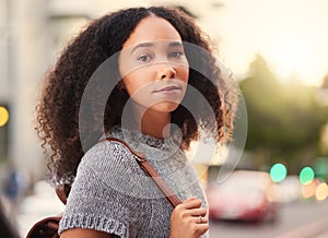 .Young, serious and portrait of a woman in the city waiting for a cab, lift or public transport. Beautiful, confident