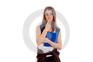 Young serious student girl with blue folders for notebooks in hands posing isolated on white background in studio