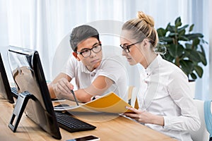 young serious student pointing on exercise book