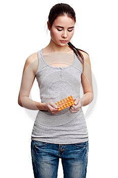 Young serious woman holding meds in the hands
