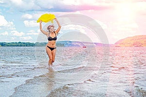 Young sexy adult woman runs on water and waving