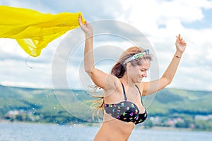 Young sexy adult woman runs on water and waving