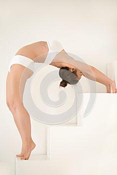 Young attractive woman Standing Backward Bend, white color photo