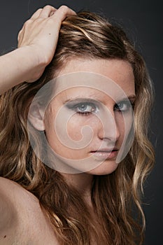 Young blonde woman portrait on gray isolated