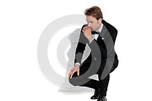 Young sexy businessman slouching, resting his arm on his lap photo