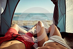 Young sexy couple looking at sea from tent