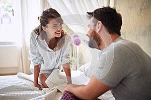 Young sexy couple in underwear having a foreplay in bed in the morinig on valentines day. Intimacy, passion, erotic concept