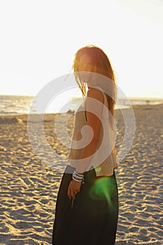 Young sexy girl on the beach at sunset in a swimsuit