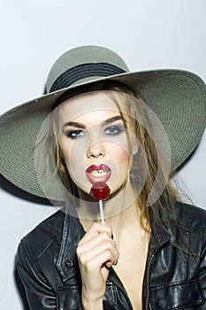 Young girl in a hat with lollipop