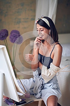 Young sexy girl painter listening to the music while painting