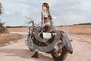 Young sexy girl posing on a motorcycle at sunset. Motor sport concept