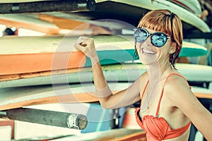 Young girl in red swimsuit - surfer with surf board posing on the Nusa Dua beach, tropical Bali island, Indonesia