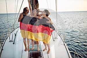 Young sexy girls posing with flag of Germany on a yacht