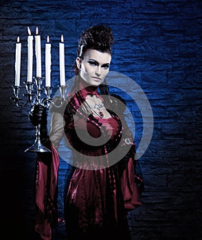 A young and lady vampire holding candles